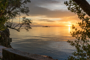 Sunset in the Gulf of Tomini, seen from the Togian Island Batudaka in the north of Sulawesi in Indonesia. The Togian Islands in the Gulf of Tomini are a paradise for divers and snorkelers