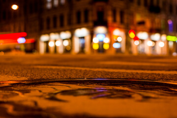 Nights lights of the big city, the night street. Close up view of the level of a manhole on the...
