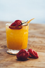 Cocktail naranja refrescante sobre base de madera y chile picante chipotle © moises
