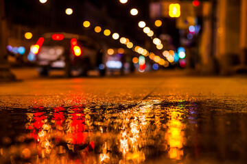 Nights lights of the big city, the main city street with parked cars. Close up view from the level...