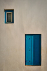 Obraz na płótnie Canvas Greek architecture abstract background - whitewashed house with blue painted window blinds