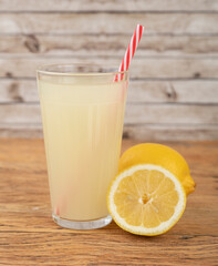 Sicilian lemon juice in a glass with fruits over wooden table