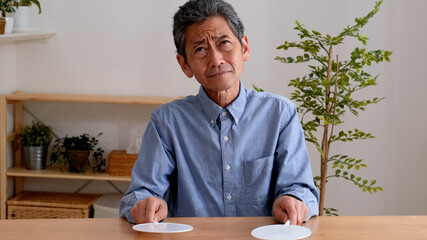 どちらのプレートを掲げるか悩むシニア男性