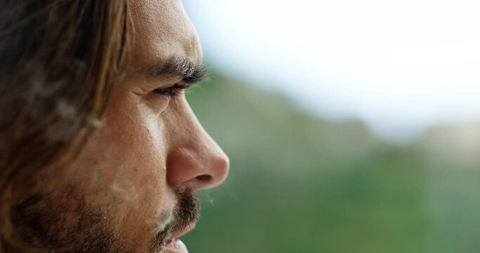 Close view of a handsome man smoking a cigarette, there is smoke coming from his mouth. He has a beard and long brown hair.  - Red Camera 4K