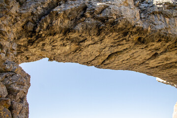 Flowers in spring, and natural stone arch in northern Spain