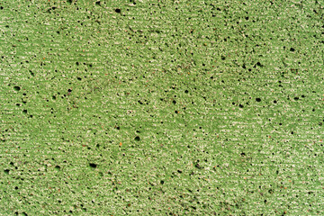 Concrete wall painted in green color. Close up view