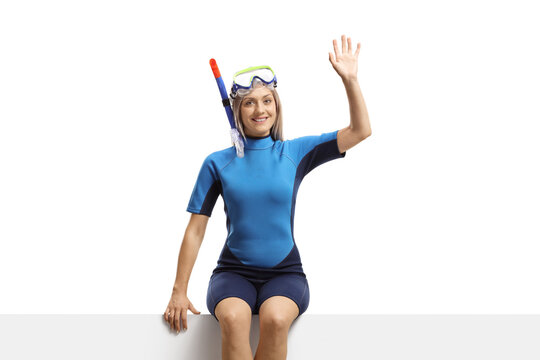 Woman In A Wetsuit And A Diving Mask Sitting On A Banner And Waving