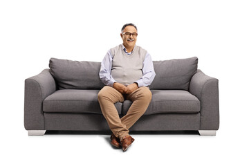 Mature man sitting on a sofa and smiling at camera - Powered by Adobe