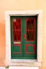 Czerwono zielone drzwi wejściowe do starego budynku na starym mieście. 