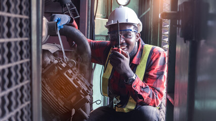 African engineering engine machine controller checking, working with walk radio communication or...