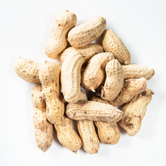 top view of pile of unpeeled peanuts on white