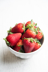 strawberry in white bowl on white background