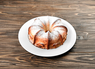 Casserole with jam and poppy seeds on a wooden background.
