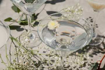 Summer drinks in martini cocktail glasses on warm grey concrete. Beautiful composition with...