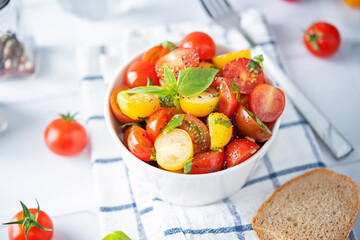 Colorful tomatoes basil pepper salad in a bowl
