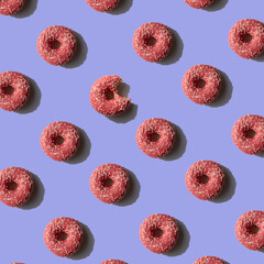 Pink Donut pattern on purple background. Sunlight minimal trendy concept. Top view