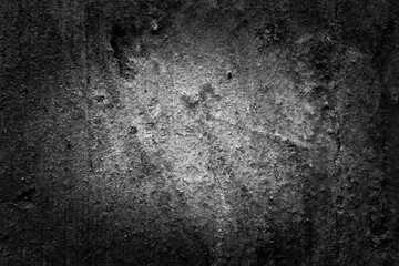Old and ruined dark wall with a shabby paint. Close up view, central illumination