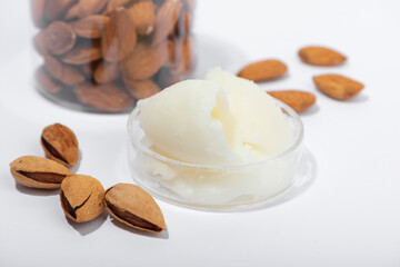 Sweet almond butter and natural almonds on white background.
