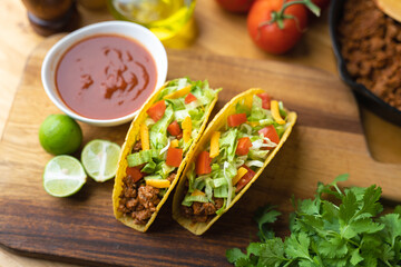 hard shell taco on wooden board with lime