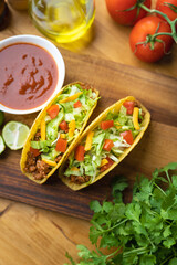 hard shell taco on wooden board with lime