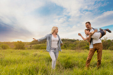 Fototapeta premium Young happy family in a field