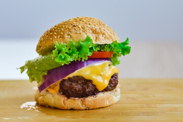 Burger with beef, onion, cheese, tomato, and lettuce for the national beef burger day