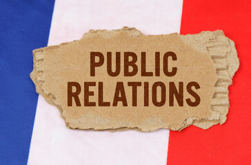 Against the background of the French flag lies cardboard with the inscription - Public Relations