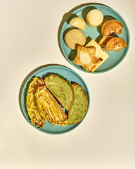 Sweet pastries on plates on a light background, top view with space for text