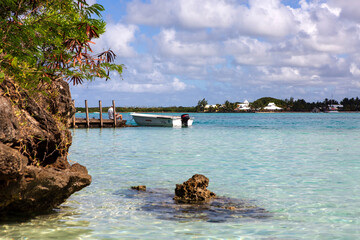 Bootstour auf Mauritius, Angler auf einem Bootssteg an der Küste der Insel im indischen Ozean und blauer Himmel.