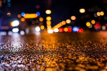 Rainy night in the big city, the light from the headlamps of vehicles approaching on the road....