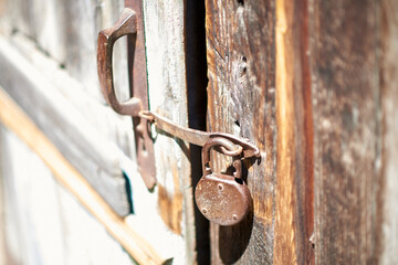 Antique rusty padlock on a wooden door
