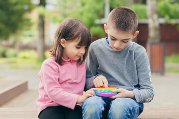 Colorful antistress sensory toy fidget push pop it in kid's hands  - obrazy, fototapety, plakaty