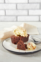 Brownie chocolate dessert with scoop of creamy nut ice cream on plate with napkin
