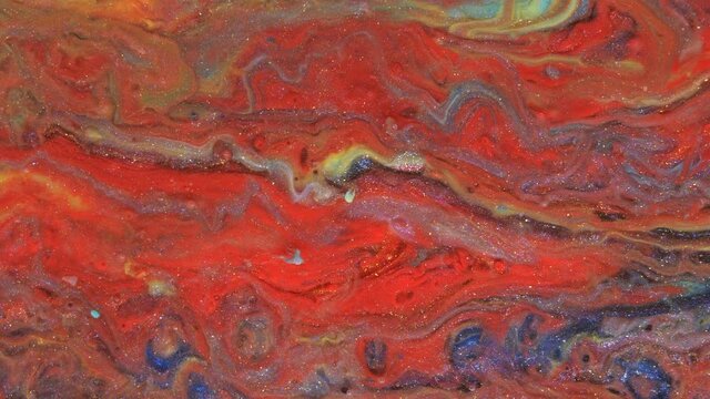 Abstract bright red and light pastel streams flow across the plane on a blue background. Marble texture. Fluid art. Liquid abstractions.