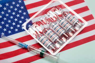 USA vaccine against coronavirus covid concept. Vaccine ampoules against the background of the national flag. Pharmacology and Medicine USA concept.