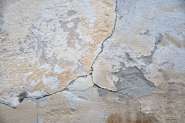 Empty old plastered wall texture. Painted problem wall surface. Dilapidated building facade with damaged plaster. Crack.