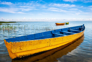 Beautiful landscape with close-up boats on the lake and blue sky with white clouds. - Powered by Adobe