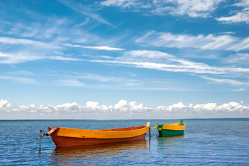 Fototapeta na wymiar Beautiful landscape with boats on the lake and blue sky with white clouds.