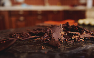 Cooled chocolate mass collected with a confectionery scraper on a marble surface. Concept of World Chocolate Day