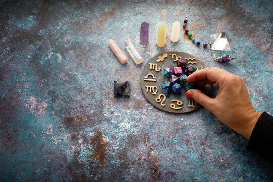 zodiac horoscope symbol with fortune-teller hands and healing crystals on rustic background
