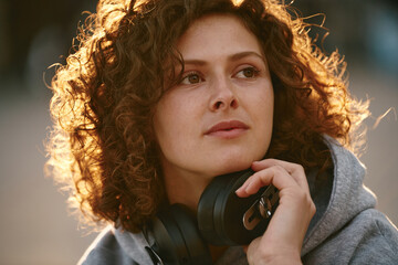 Close up of young woman holding headphones and enjoying her free time.