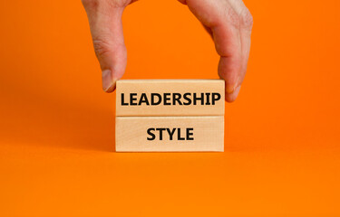 Leadership style symbol. Wooden blocks with words 'Leadership style' on beautiful orange background. Businessman hand. Business and Leadership style concept. Copy space.