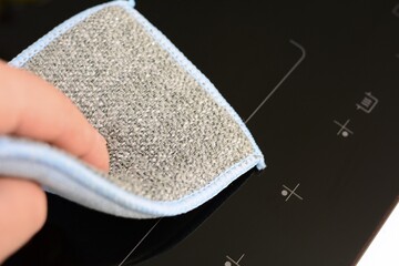 Cleaning the induction hob, cooker with a soft sponge. Using the cleaning sponge for dust removal...
