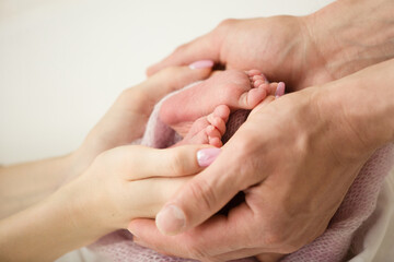 Children's feet in hold hands of mother and father. Mother, father and Child. Happy Family people concept.