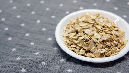 Oats in wooden bowl and scoop on white background. Top view, high resolution product. Healthy food Concept.