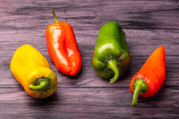 red yellow and green bell peppers on a wooden table