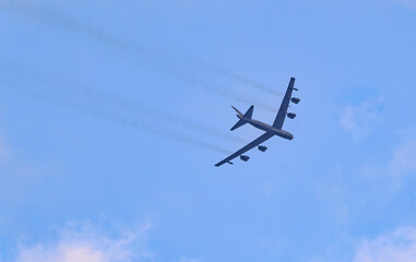 Boeing B-52 Stratofortress bomber flying in sky with smoke trail 
