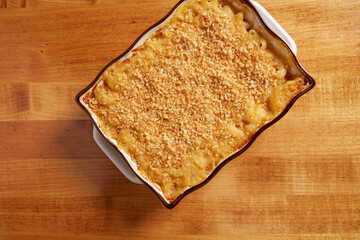 Top view of Mac n Cheese in a ceramin baking pan on a wooden surface