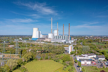 Obraz premium Aerial view of coal fired power plant during daytime with sunshine