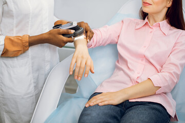 Prevention of melanoma concept. Unrecognizable female afro american doctor examines birthmarks or...